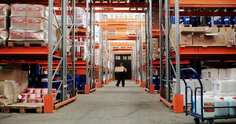 Employee carrying a box through a warehouse image link to article
