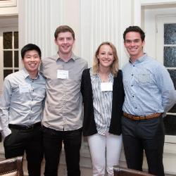 Four students posing together at a dinner event in 2018.