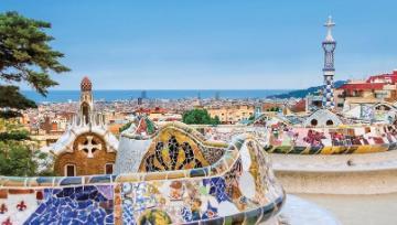 A scenic view of a Spanish coastal town with colorful buildings and the sea in the background.