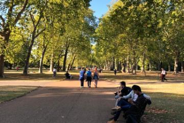 Alt text: Pathway in Hyde Park, London with people sitting and walking.