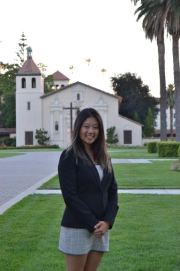 A person standing in front of a white church building.