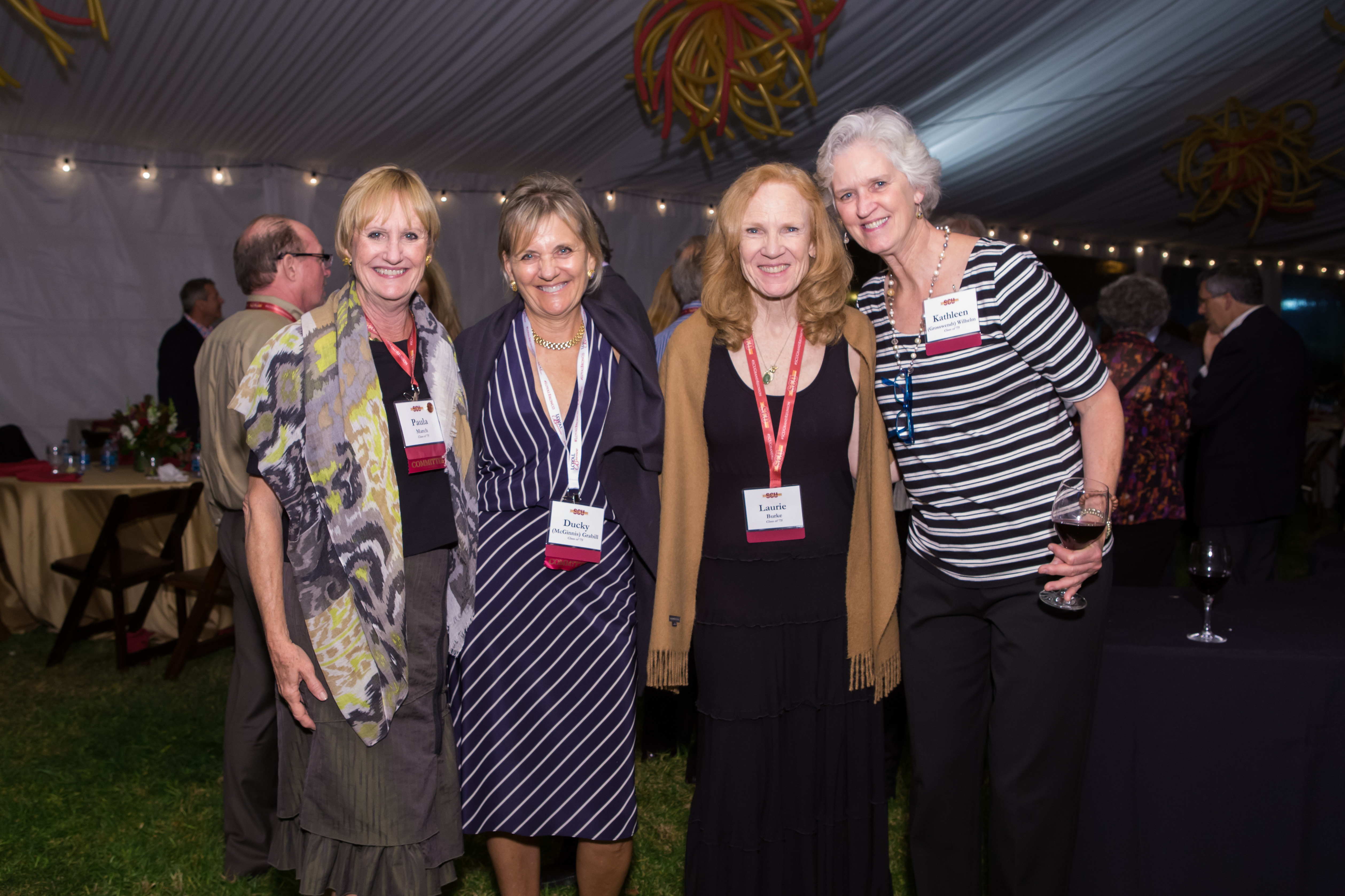 Four women form the class of 1975 gather together and smile