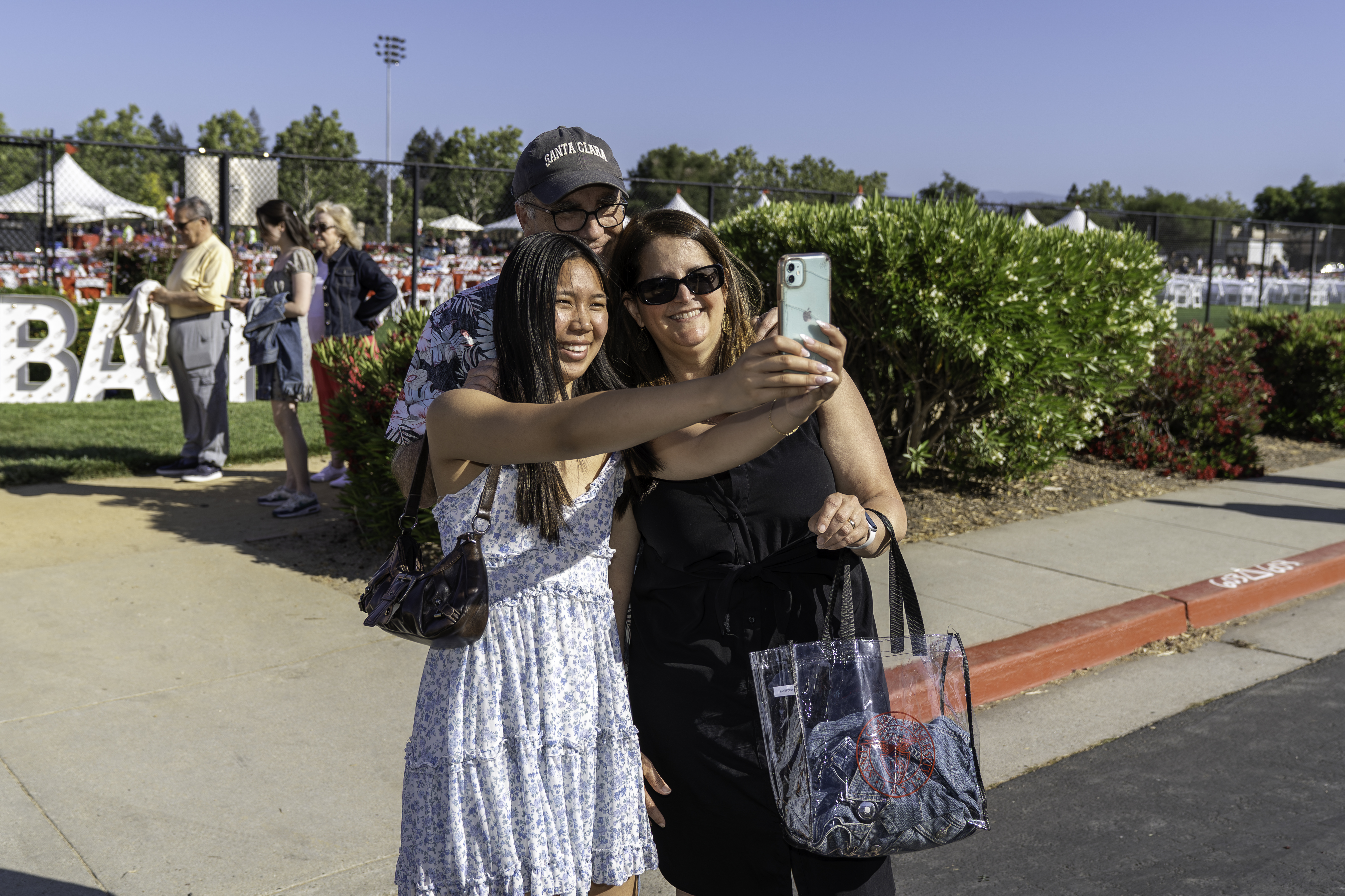 a family taking a selfie in front of the Grad Bash entrance 