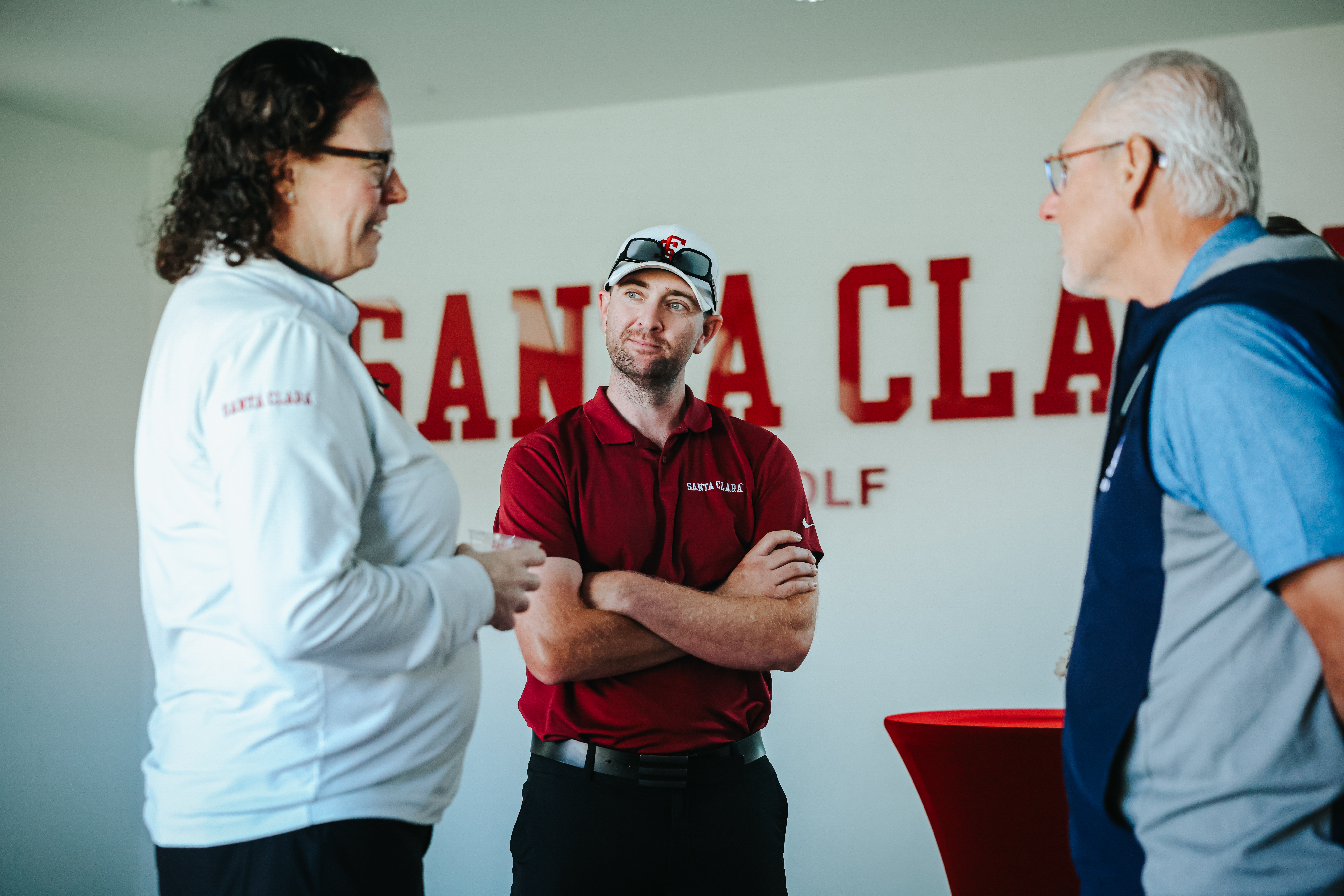 Athletic Director Heather Owen talks with two men inside the SCU Golf Facility