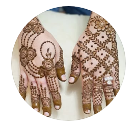 Two hands sit palm-down with elegant henna tattoos covering them. 