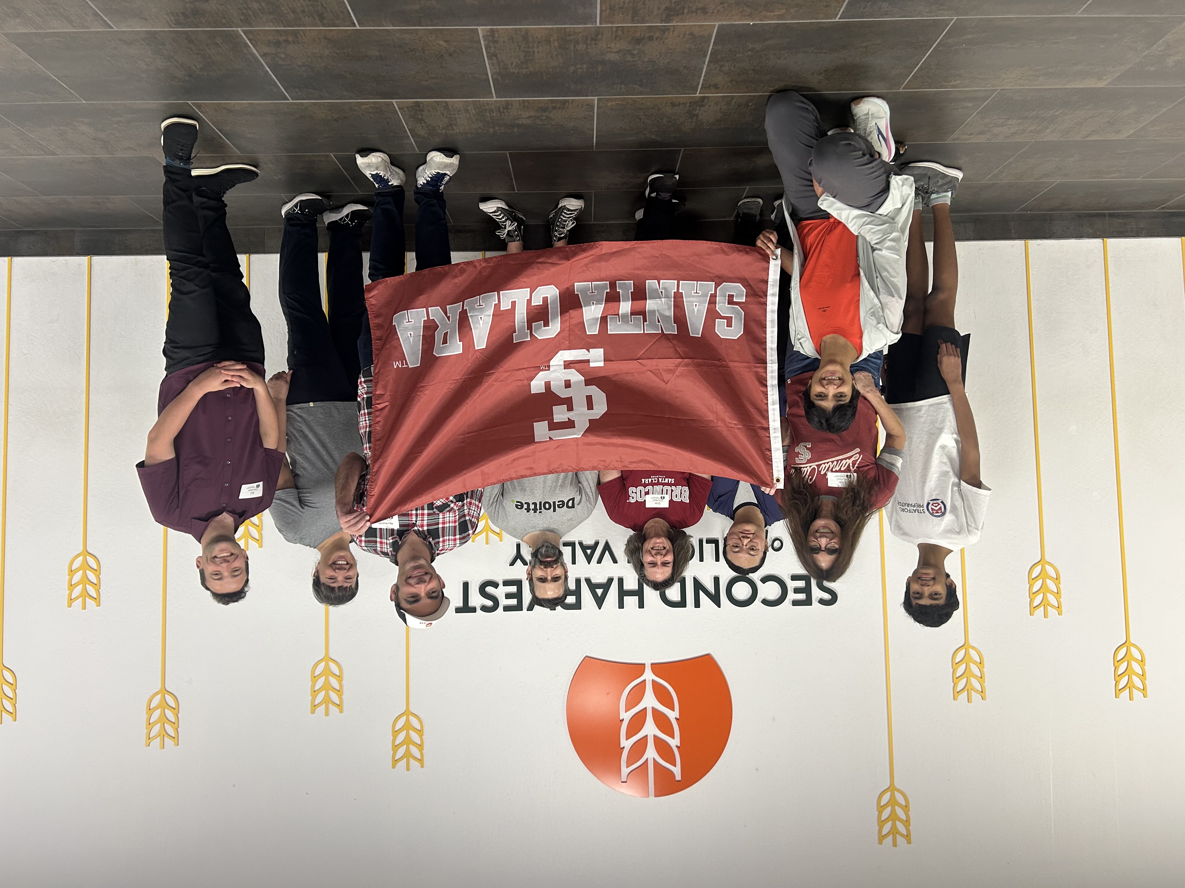 Alumni smiling around Second Harvest and SCU Logos