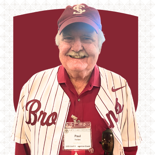 A smiling man in a Santa Clara University baseball cap and athletic shirt. His nametag reads 