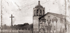Alt text: Historical university building with a cross statue in an old photograph. 