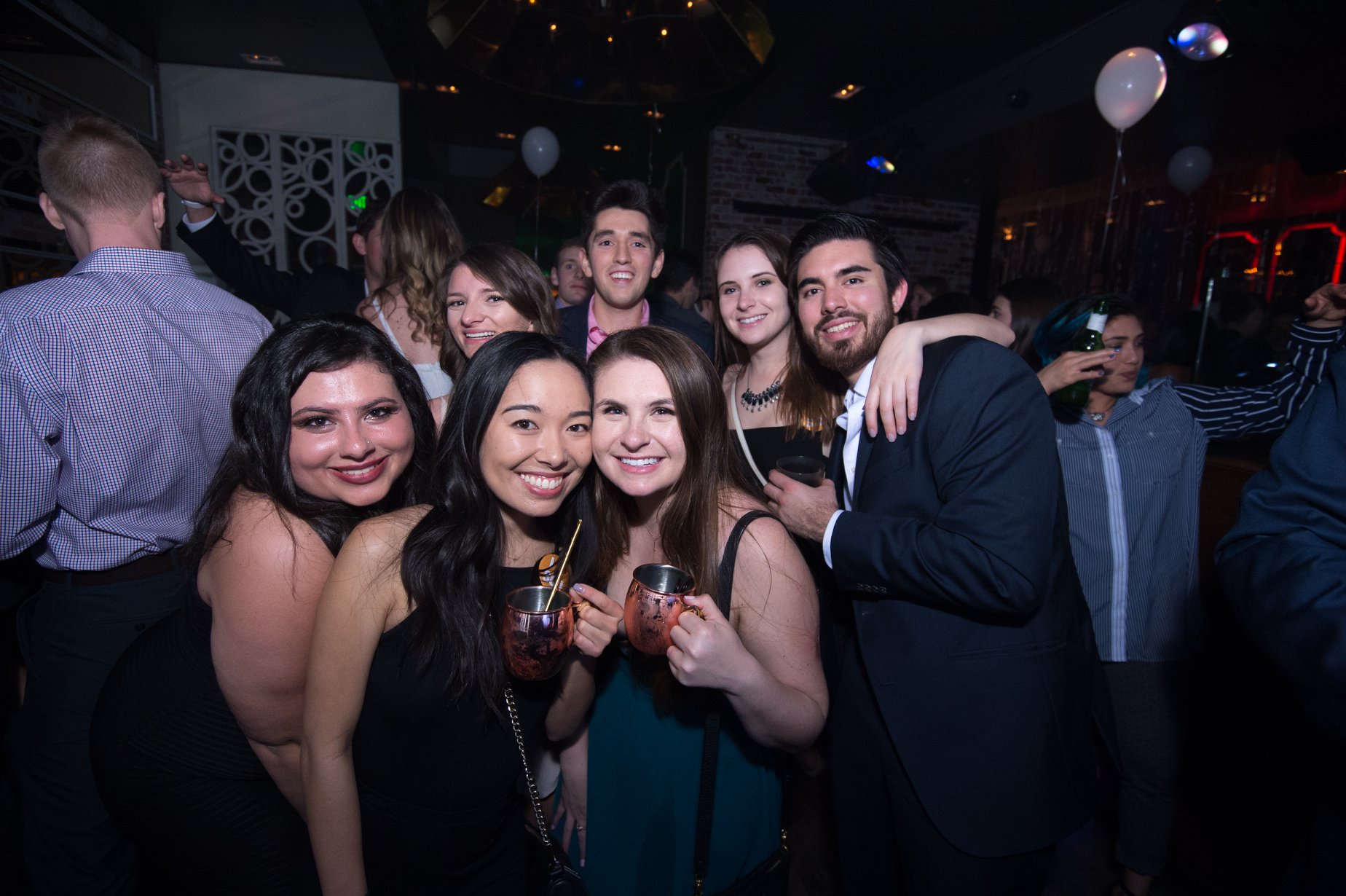 Formally dressed young alumni at an indoor party