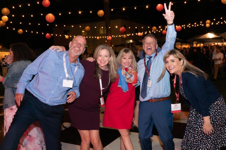 Five members of the class of 1996 posing on a dance floor in the Mission Gardens