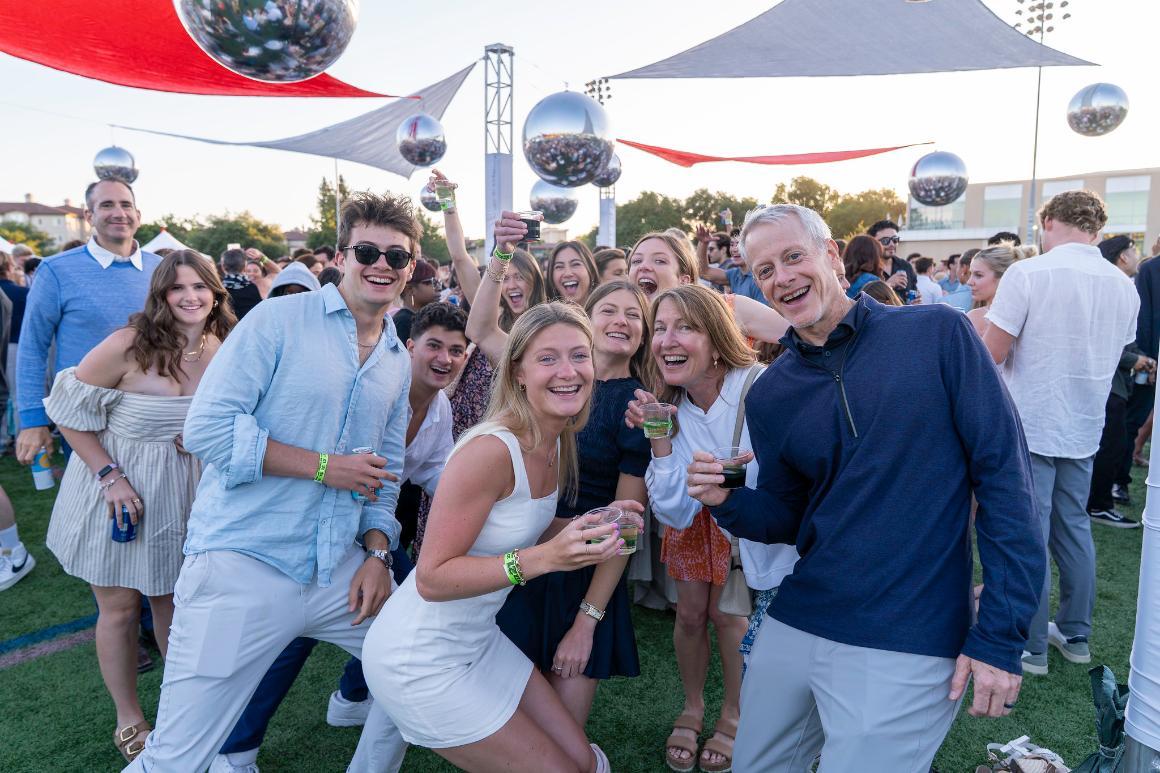 Family and friends smiling and posing for the camera on the dance floor at Grad Bash 2025.