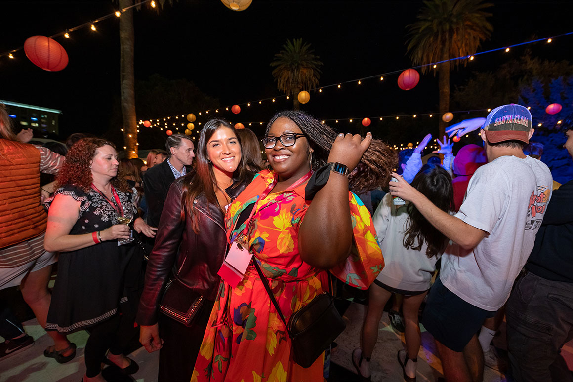 Two women dancing in a large group of dancers 
