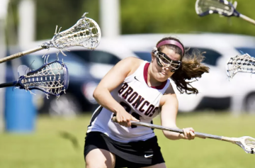 A woman playing lacrosse during a game.