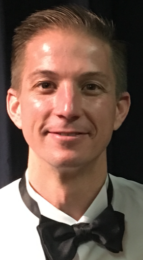 A person wearing a bow tie, with a neutral background.