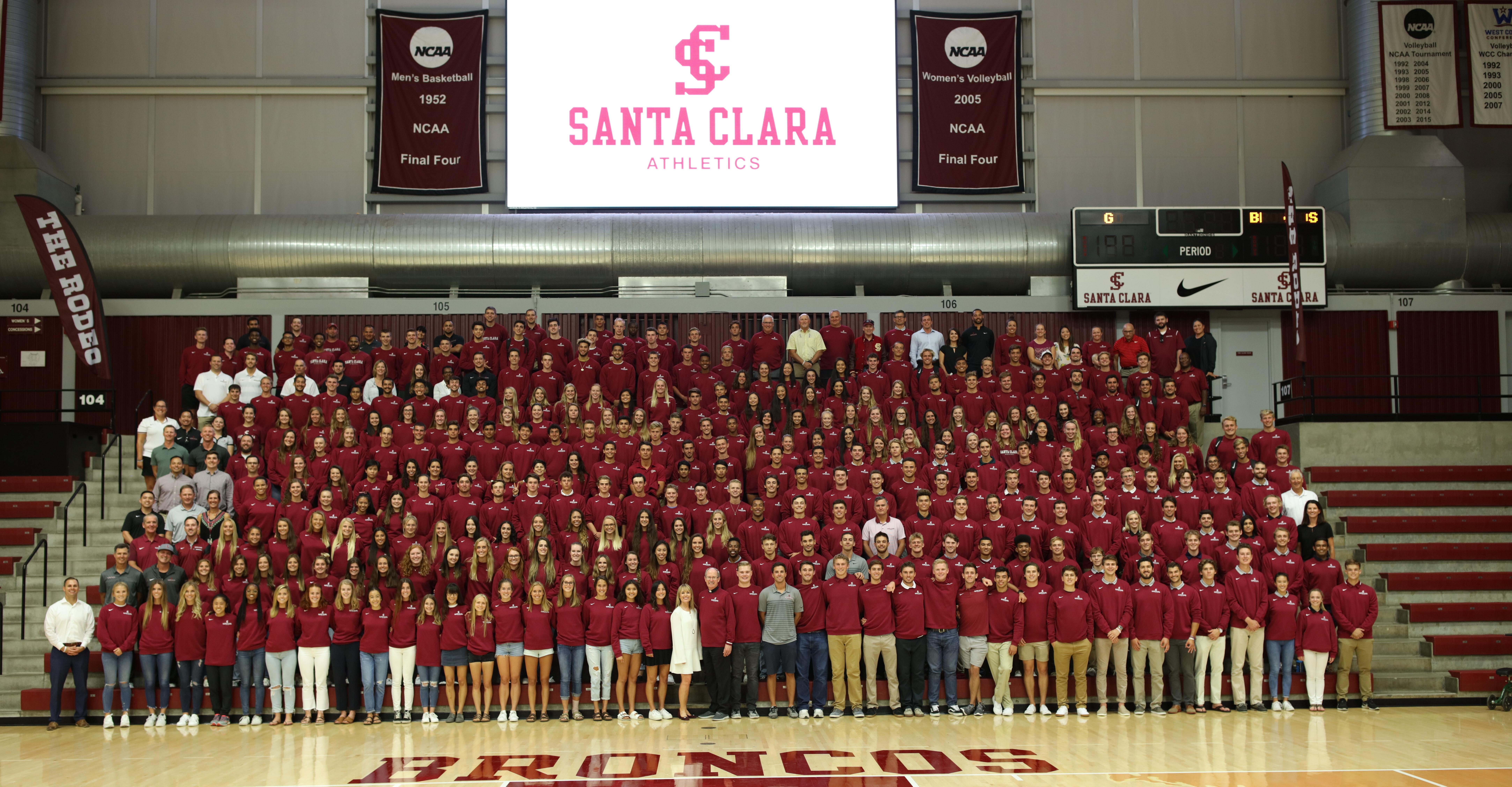 A group photo of student athletes in a gymnasium with 