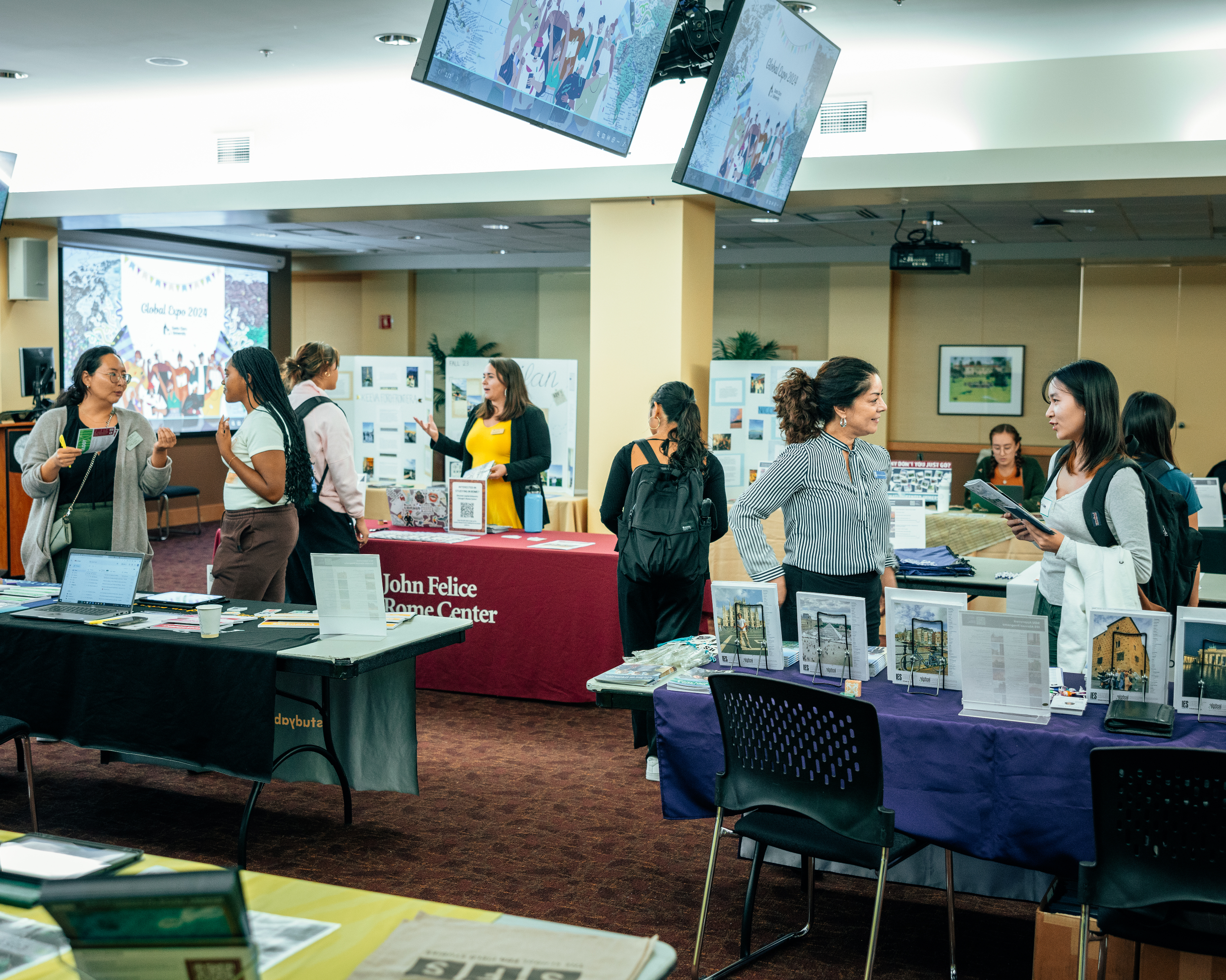 Decorative; students speaking with international partners at display tables
