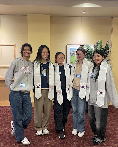 Five students gathered wearing Study Abroad graduation sashes