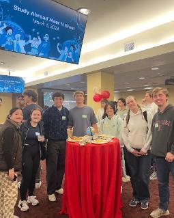 Group of students smiling around a table