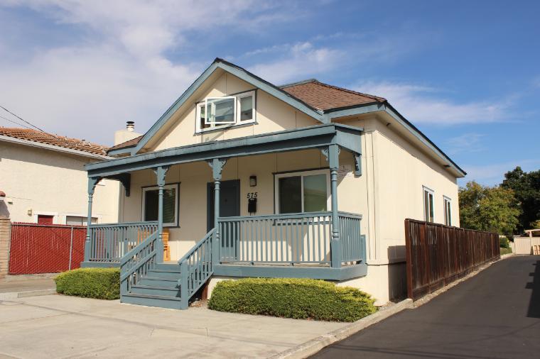 A single-story house with a front porch and blue trim.