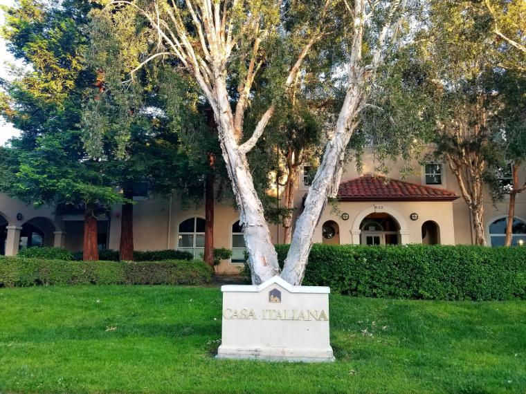 A plaque and trees in front of a building.