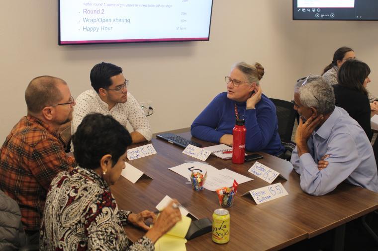 a group of faculty member sits together talking