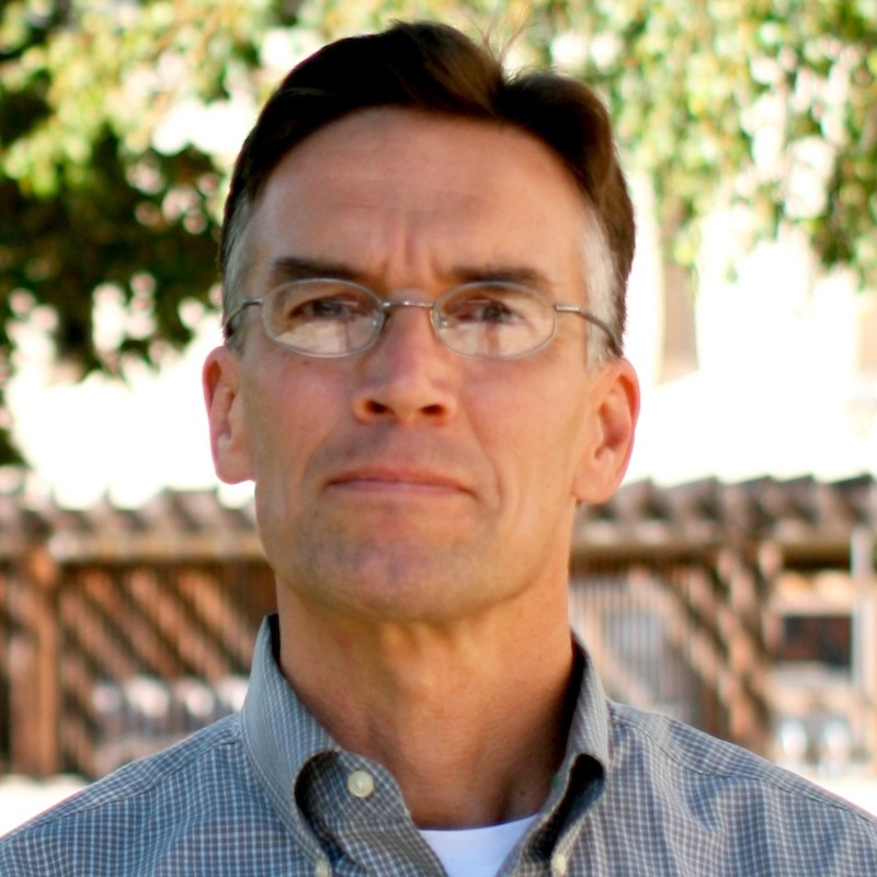 A man wearing glasses outdoors with trees in the background. image link to story