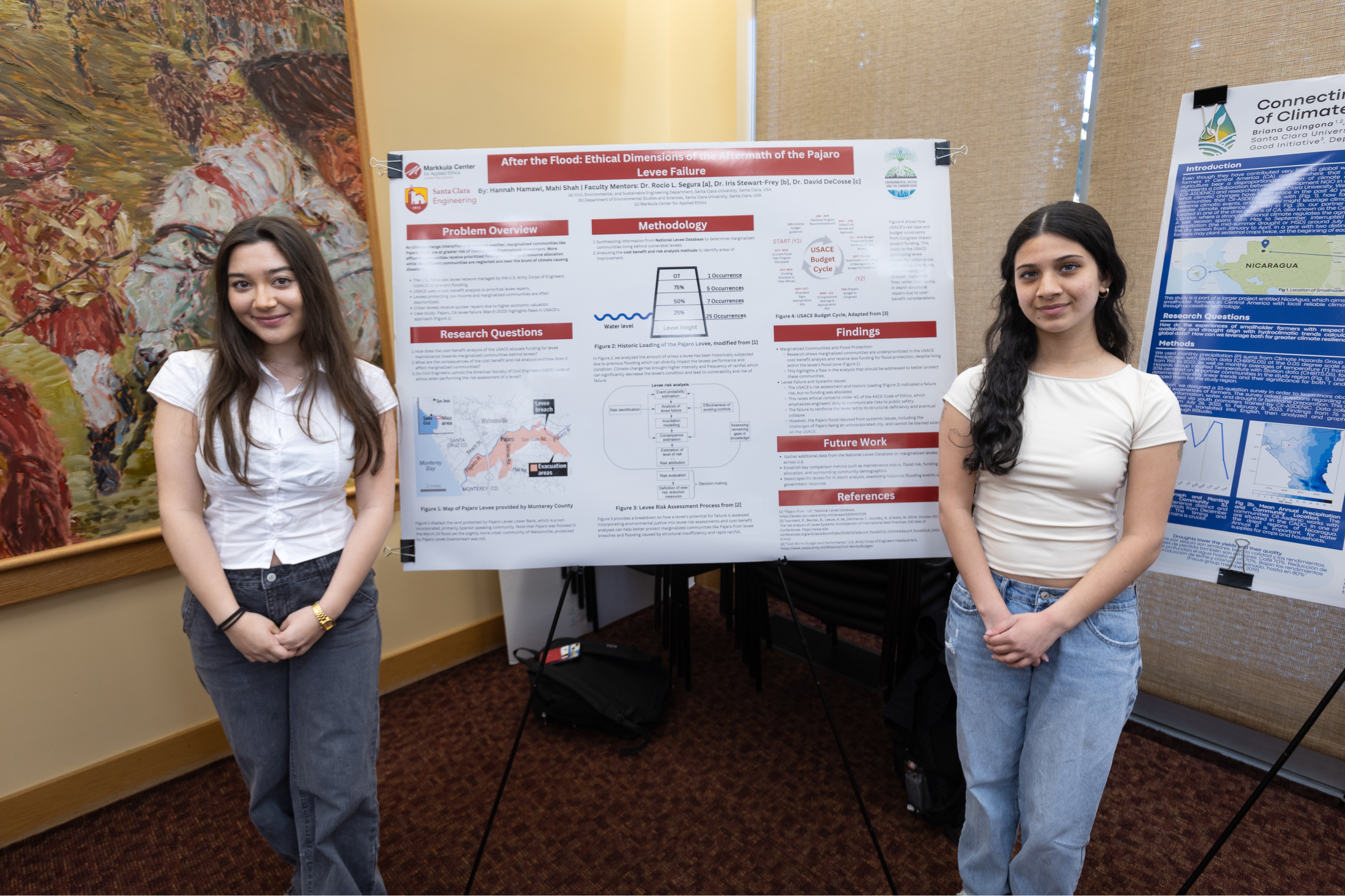 Two students stand in front of their research poster on the aftermath of a flood during the 2025 Sustainability and EJ Symposium.