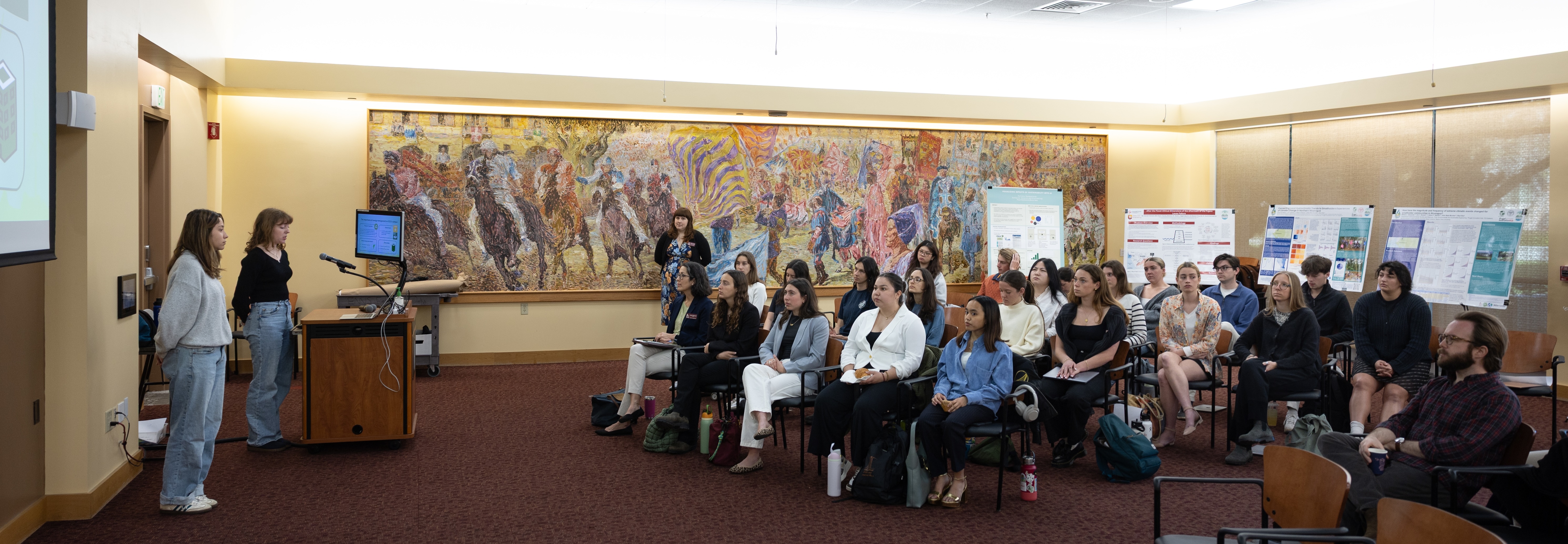 Two students present to an audience during the 2025 Sustainability and EJ Symposium.