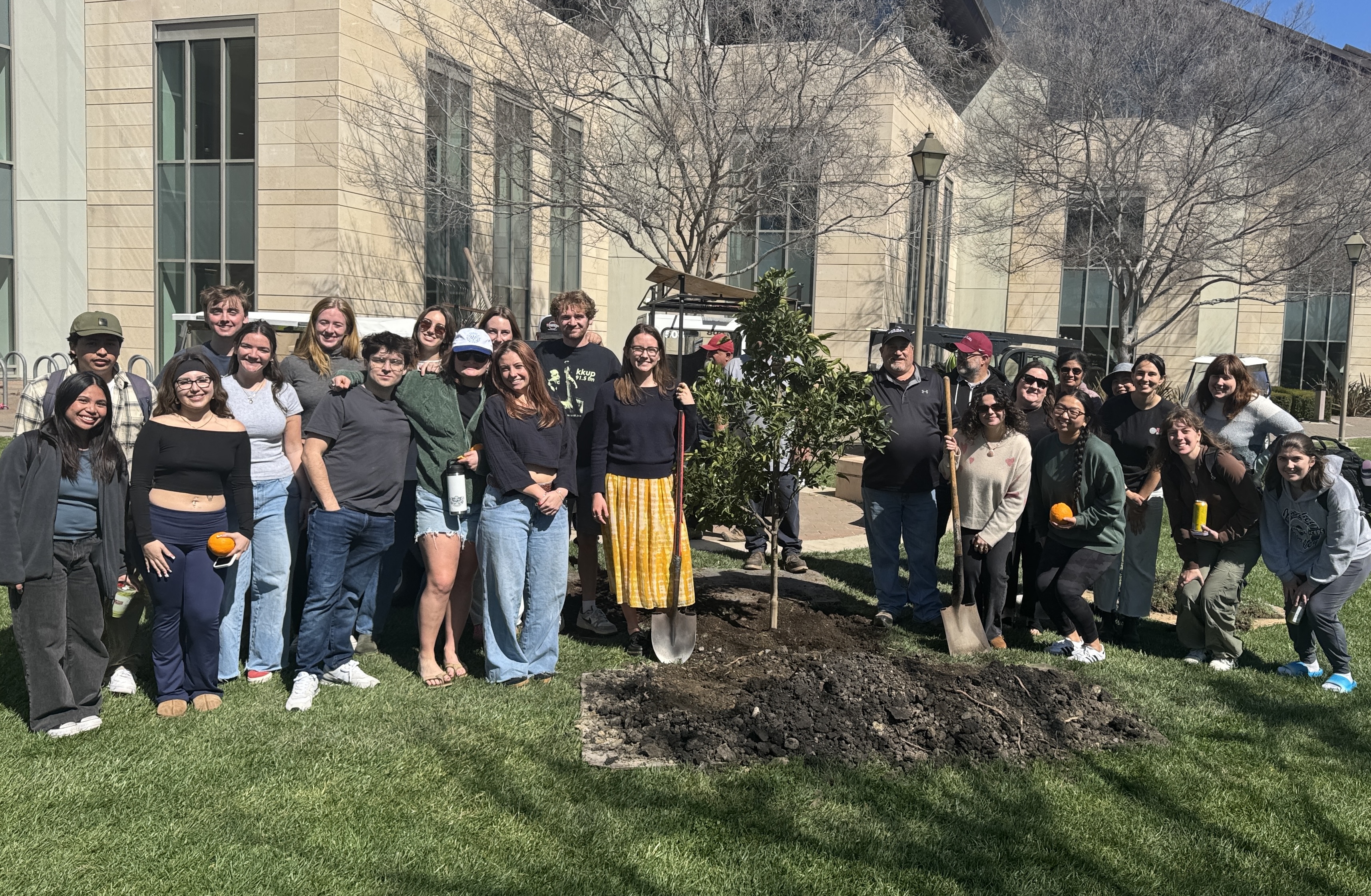a group of students and staff posed around a newly planted tree on Arbor Day 2025
