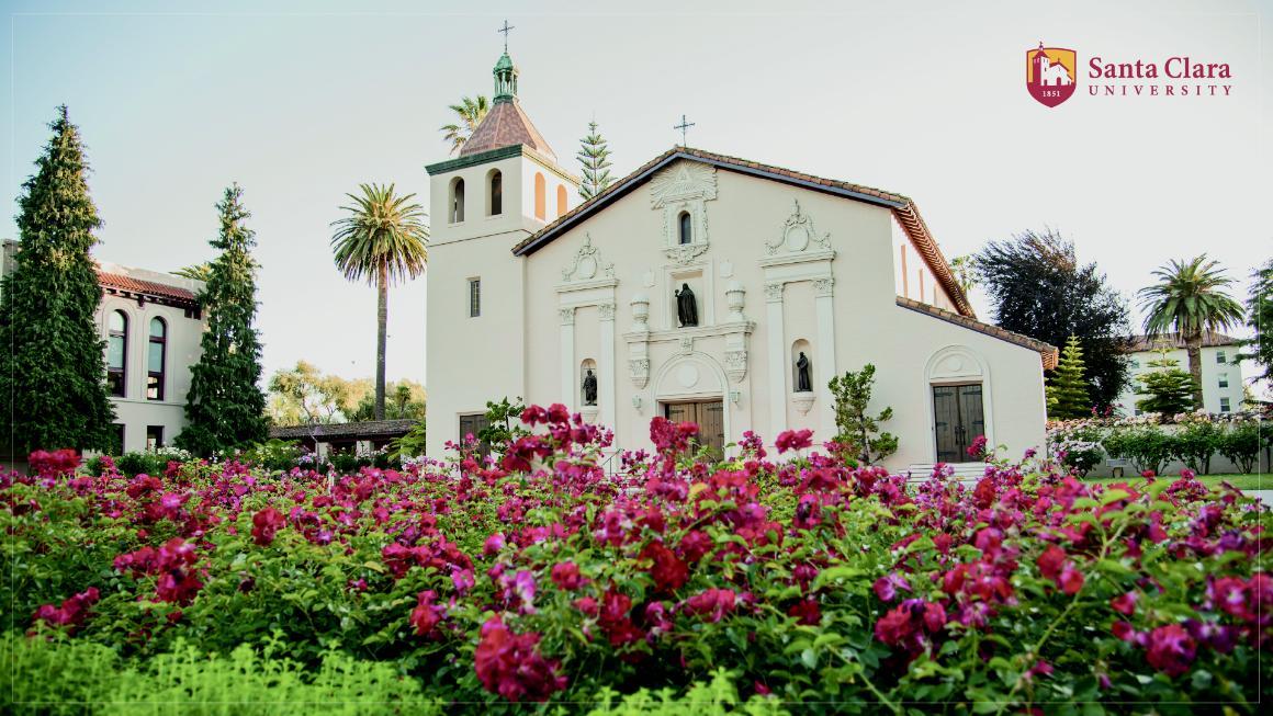 Mission exterior (front) with red flowers in bloom