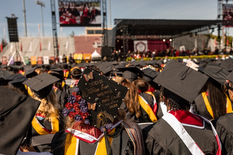 A graduate with a mortarboard decorated with Psalms 46:5