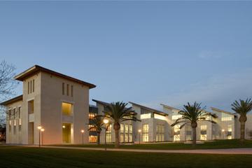 A large library building illuminated at dusk.