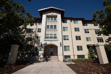 Alt text: Four-story building with arched entrance, labeled 'Finn Residence Hall'.