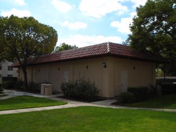 Small building labeled Pump House surrounded by grass and trees under a blue sky.