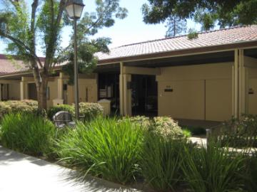 A tan building labeled 200 surrounded by greenery at Daly Science.