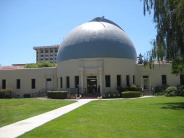 Large building with a dome labeled Ricard Observatory on a sunny day.