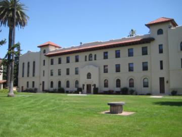 Large building labeled St. Josephs with lawn and palm tree in front.
