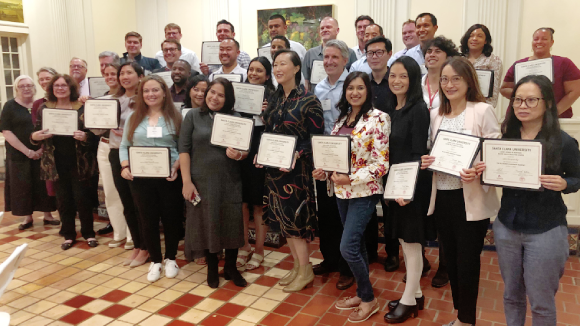 A group of smiling people holding certificates of completion