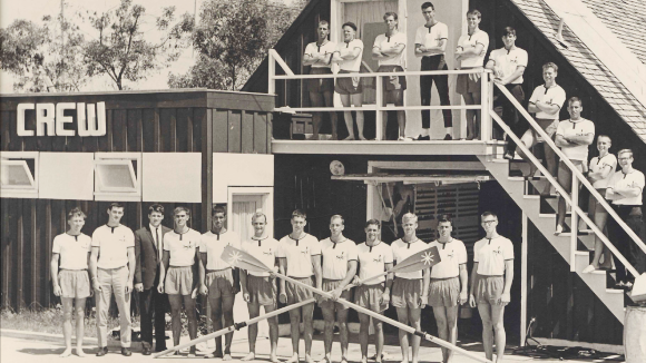 A black and white photo of a group of young men in front of a building labeled 'Crew'