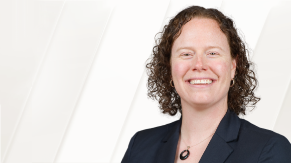 A smiling woman in a black blazer.