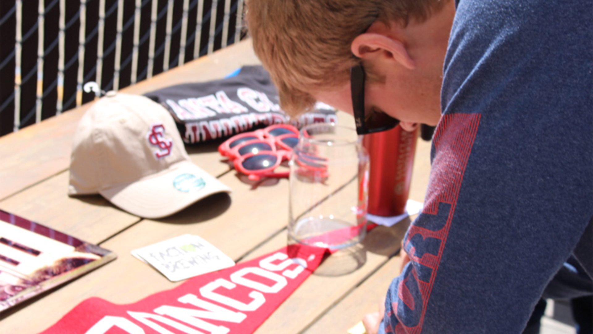 Man crouched over a table of SCU paraphernalia