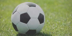 A black-and-white soccer ball on green grass. 