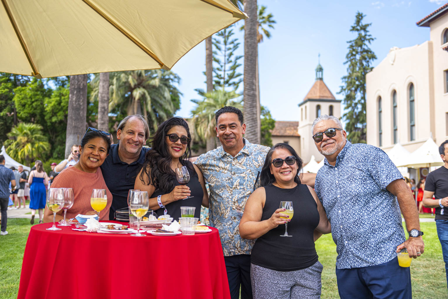 Group of alumni smiling at camera in the mission gardens 