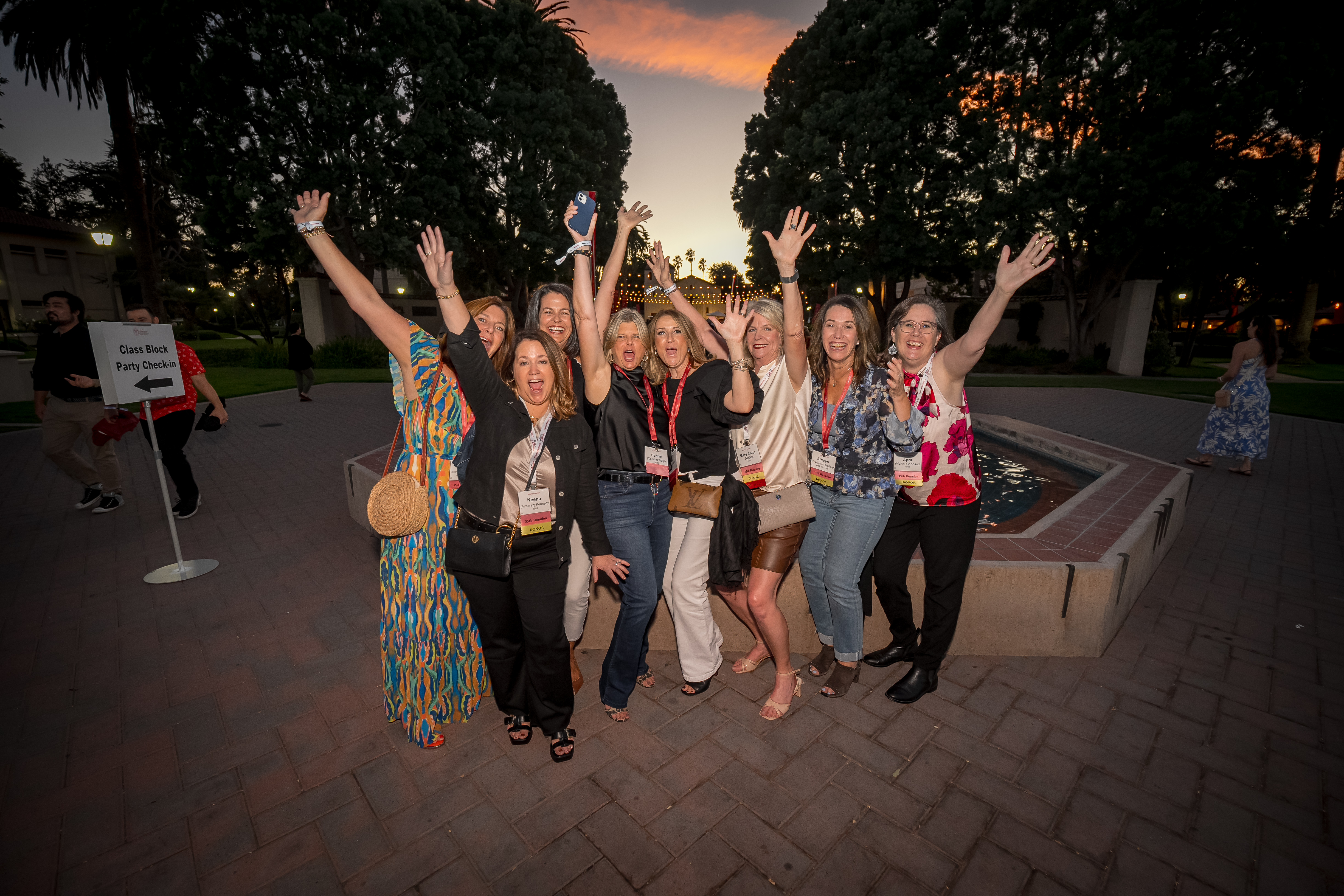 Group of women hands up happy at fountain and class block parties