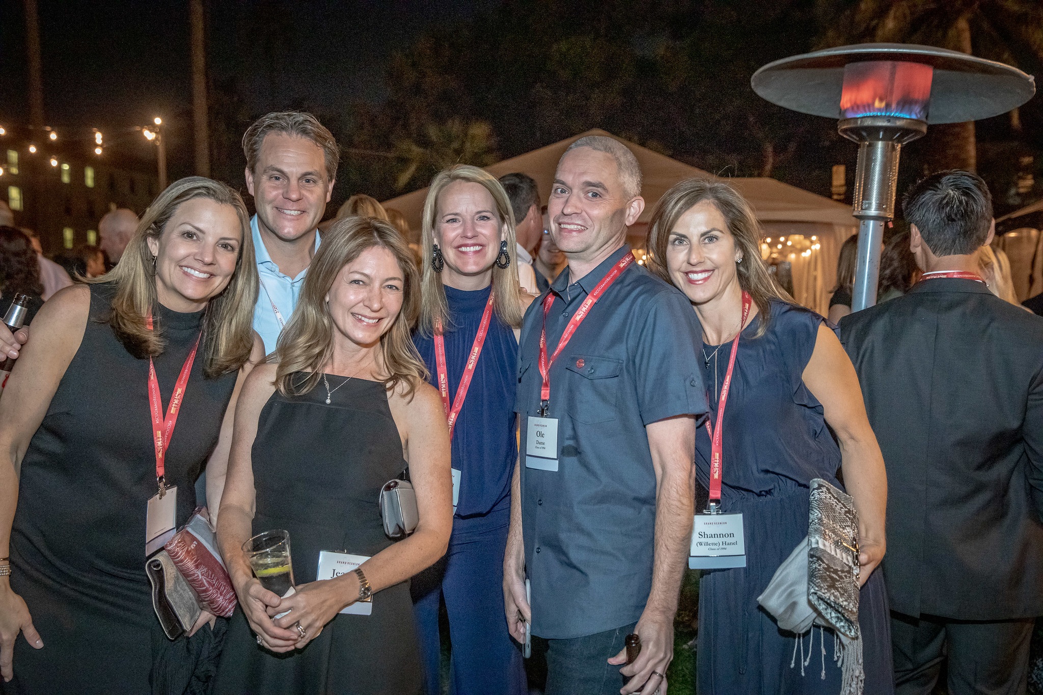 Group of alumni smiling at camera in the mission gardens