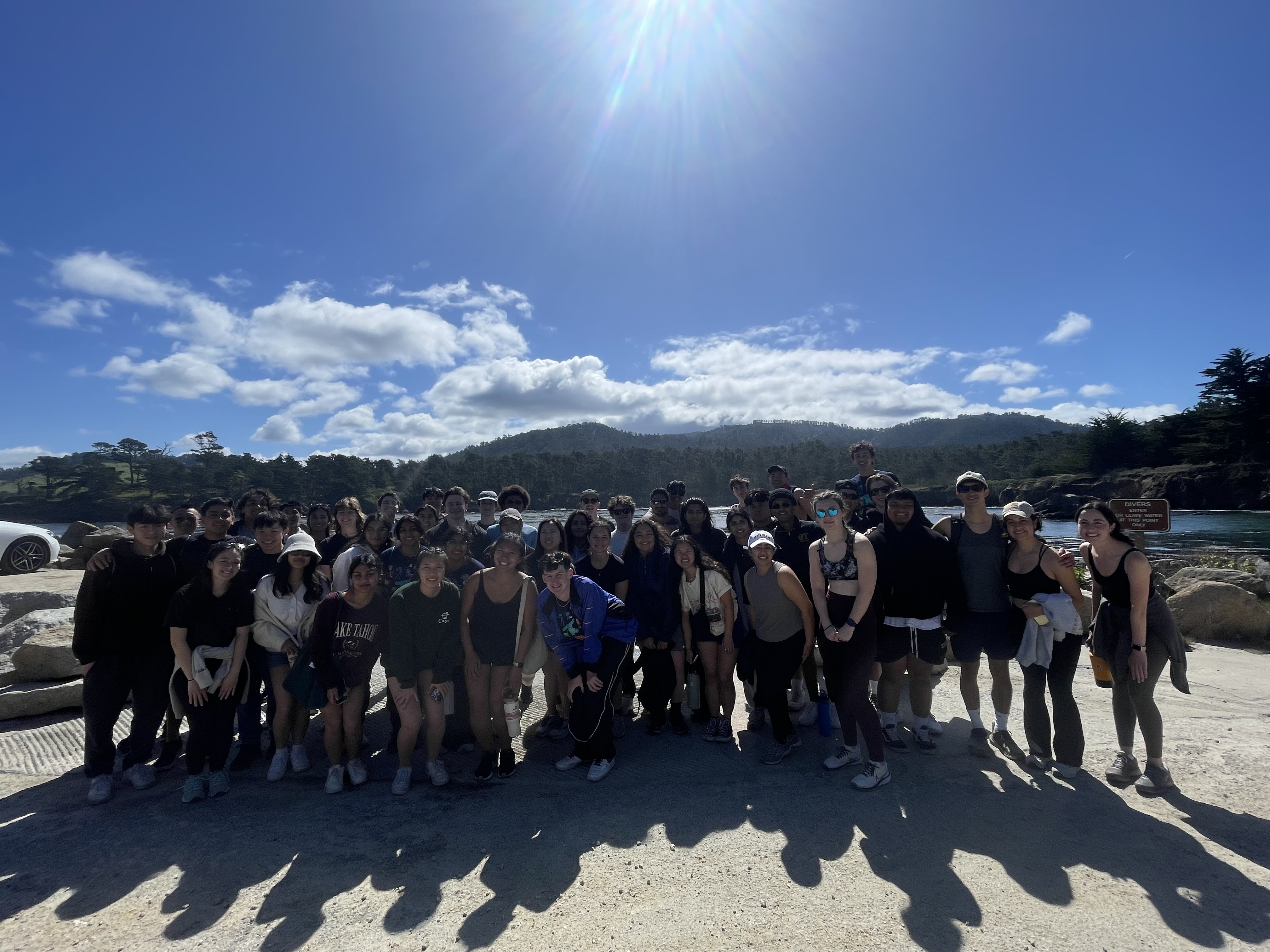 Theta Tau members posing for a photo in front of Monterey Beach.