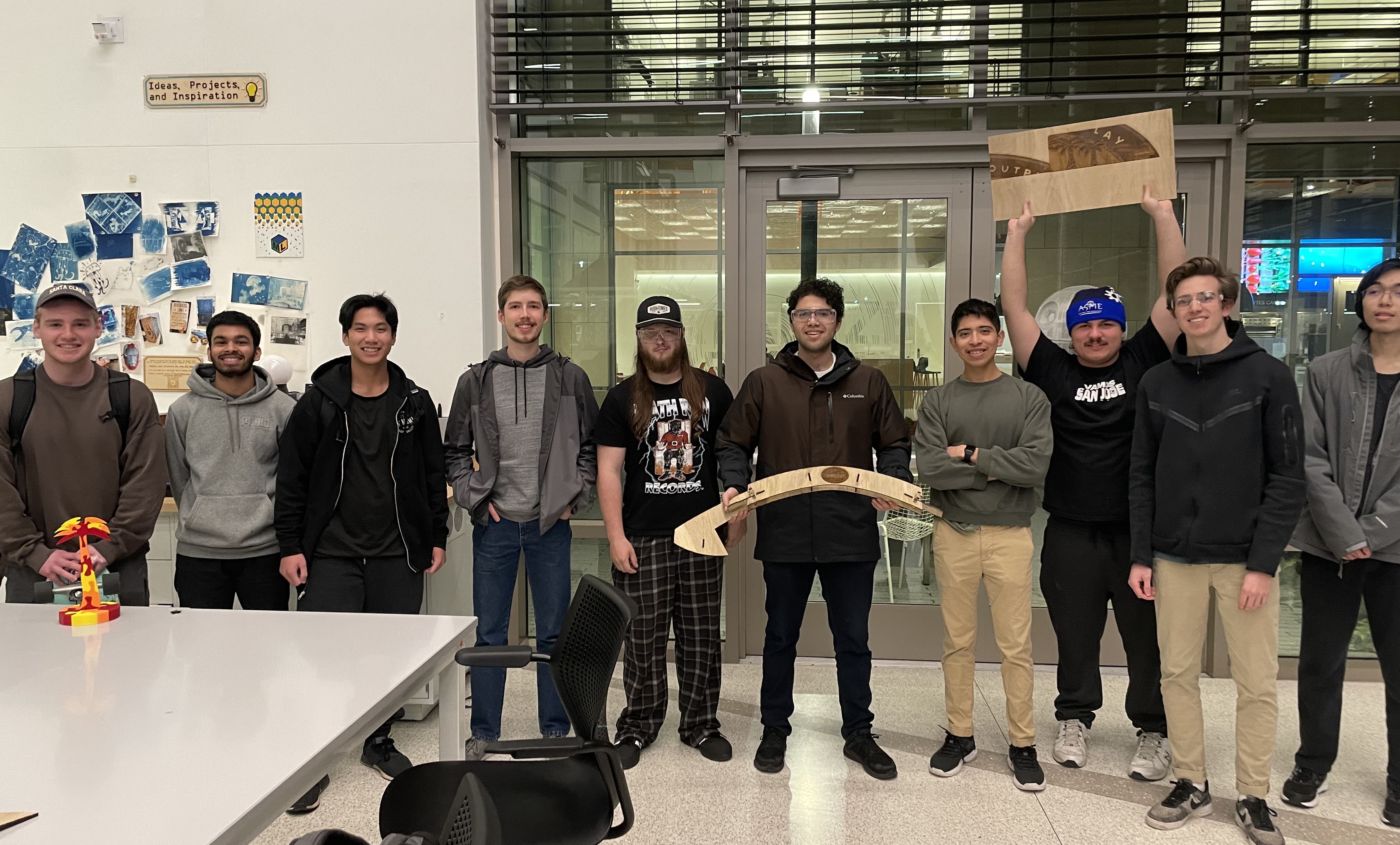 10 male ASME members inside of the maker lab with designs they created.