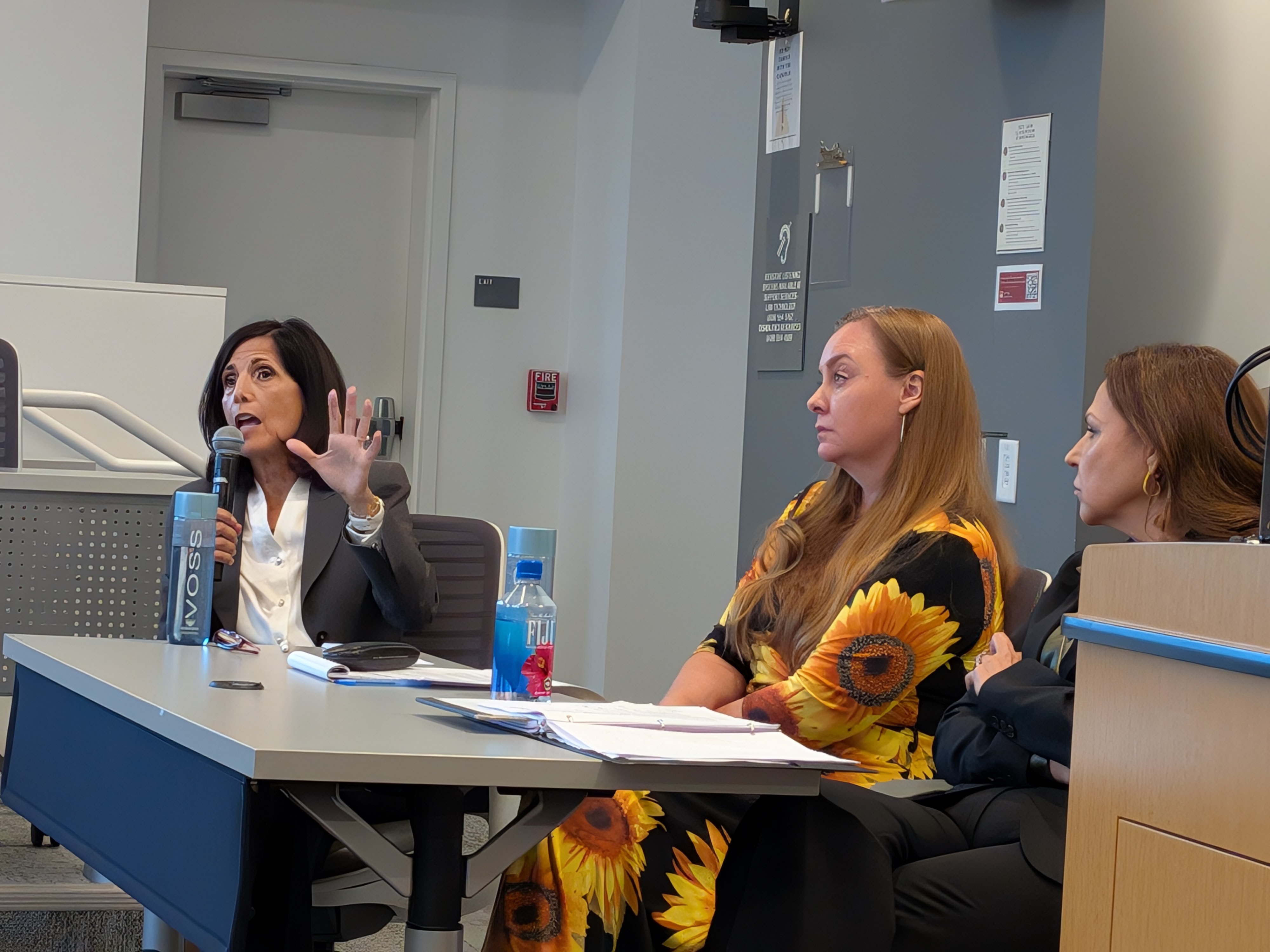 Three Panelists sitting at a desk 