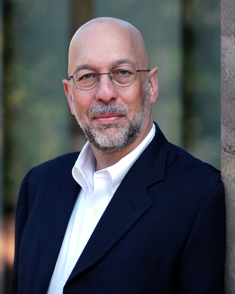 head shot of Prof. Gary Benton, white man with glasses, shaved head, grey beard, black suit and white button down shirt