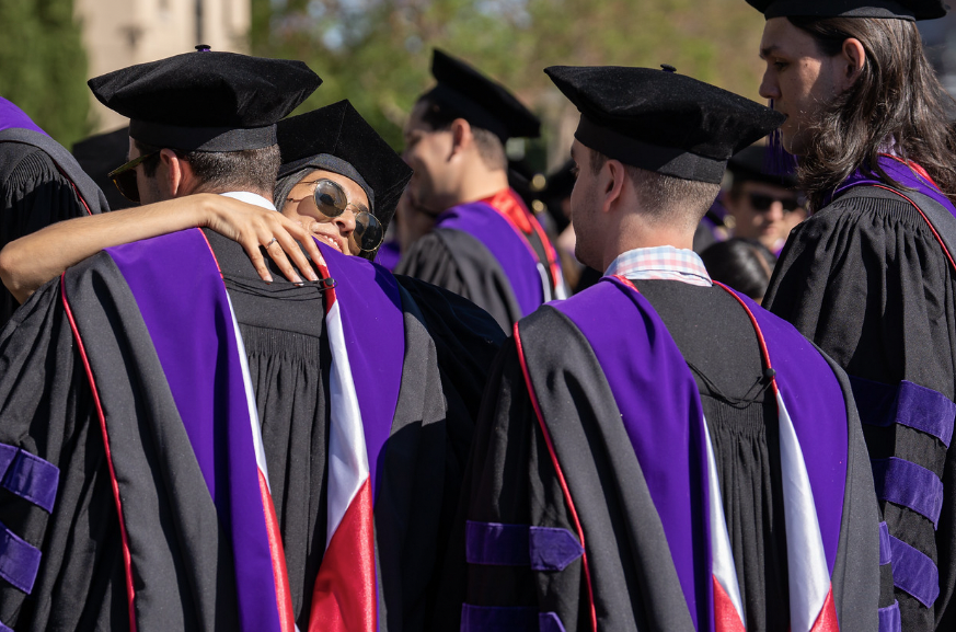students hugging at a graduation event 